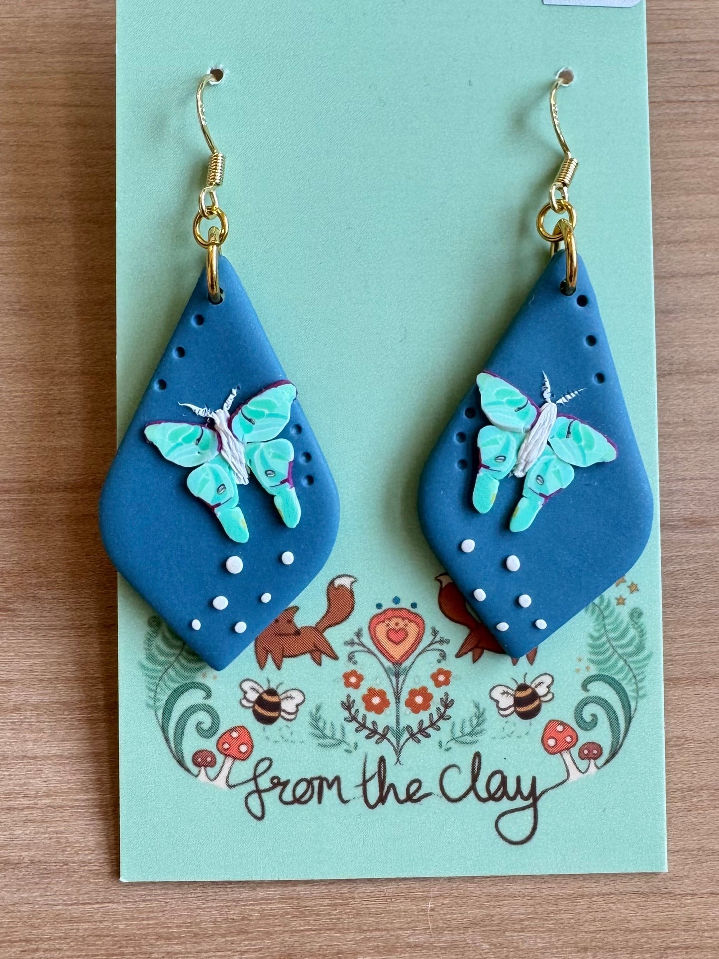 Blue teardrop earrings with flying Luna Moth made entirely of polymer clay.