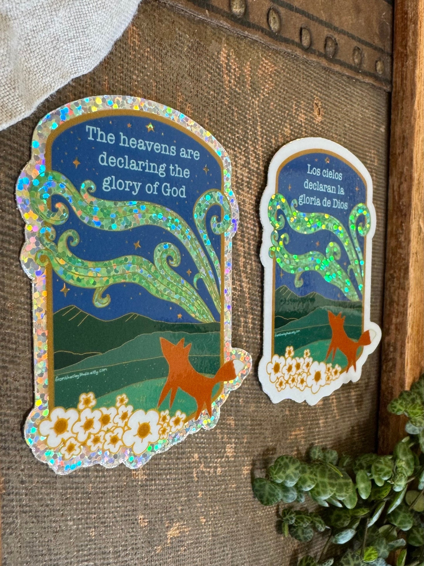 side view of two stickers with fox looking at the northern lights at night